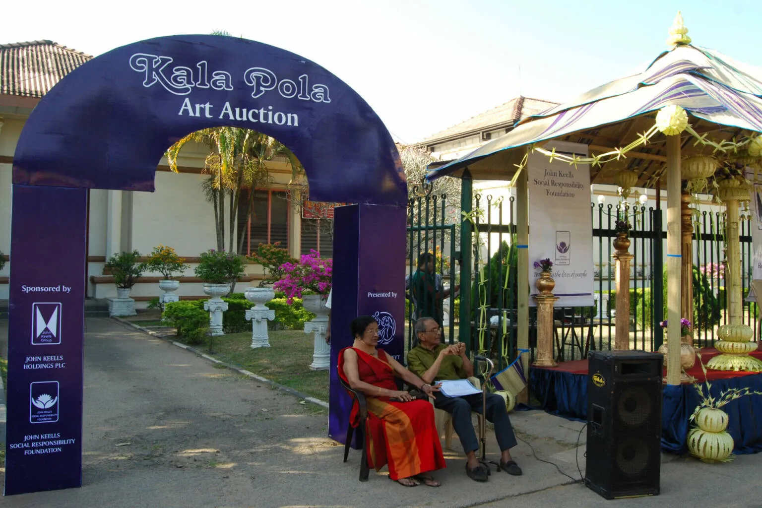 A large, ornate archway with detailed carvings, serving as a majestic entrance to a beautiful space beyond.