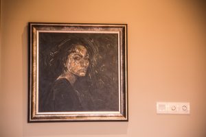 A painting of a woman elegantly displayed on a wall, showcasing artistic details and vibrant colors.